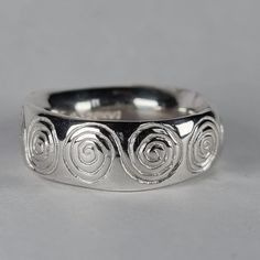 **Please note that we dispatch on Tuesdays unless special delivery express option is paid for** Sterling silver 'spirals' ring. Original design carved in wax then lost wax cast into solid sterling silver. This is a large and chunky ring, with a very rounded super smooth interior. It glides on like a silky glove. Item weighs approximately 12g in silver.  Band width 7.5mm Band thickness 3-3.5mm (uneven, and undulating thickness) First class recorded post included. Handmade Silver Band Ring, Cheap Handmade Silver Rings, Cheap Handmade Metal Rings, Chunky Silver Rings Men, Lost Wax Casting Rings Design, Spiral Sterling Silver Ring Stamped 925, Silver Spiral Ring For Anniversary, Silver Spiral Anniversary Ring, Silver Spiral Sterling Silver Ring