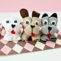 three stuffed dogs sitting on top of a checkered table