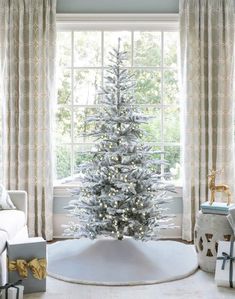 a white christmas tree in front of a window