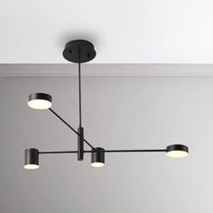 a black chandelier hanging from the ceiling in a room with white walls and flooring