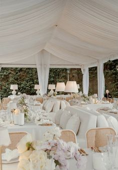 the tables are set with white linens and flowers