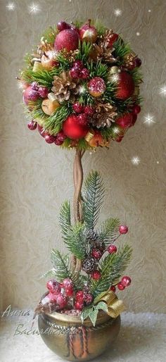 a christmas tree with balls and pine cones in a potted planter on a table