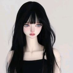 a doll with long black hair and blue eyes wearing a black tank top, standing in front of a white background