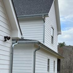 a white house with a metal gutter attached to it