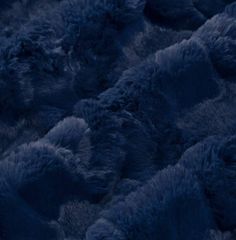 an up close shot of the fur on a sheepskin rug in dark blue tones