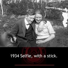 two people sitting next to each other in the grass with text that reads, 1934 selfie, with a stick