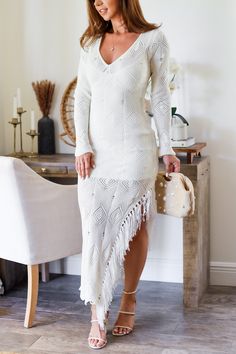 Get ready to shimmy into spring with our favorite Fringe midi dress! Perfect for adding a little fun to your wardrobe, this dress features playful fringe details that will make you stand out in any crowd. Don't miss out on this quirky and stylish addition to your collection! 100% Polyester Color: Ivory Midi Dress with Fringe Detail V neck Bust Knitted with distressed detail (see image) Long Sleeve Textured Fabric Asymmetric Fringe (see image) Half Lined No zipper/button closure Body Hugging Slight Stretch True to size Model is wearing a size Small. She is 5'6". 135lbs. Bust: 34C Waist 26" Hips 36 Spring Beach Cover-up Dress With Tassels, Maxi Length Beach Cover-up Dress With Tassels, Maxi Length Tassel Dress For Beach Cover-up, Chic Beaded Fringe Mini Dress For Spring, Spring Maxi Dress With Fringe, Fitted Midi Dress With Tassels, Chic Knee-length Midi Dress With Fringe, Chic Midi Dress For Beach Cover-up, Chic Knee-length Fringe Midi Dress