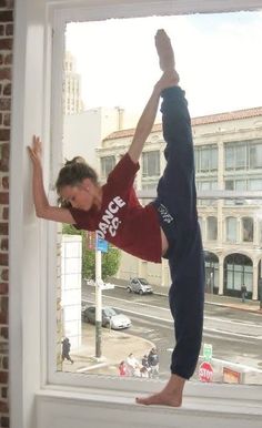 a young man doing a handstand on a window sill