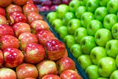 an assortment of apples and other fruits are displayed for sale at a grocery store in the united states