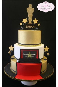 a three tiered cake decorated with gold stars and an award for the best actor