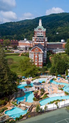 an aerial view of a resort with a pool and tennis court in the foreground