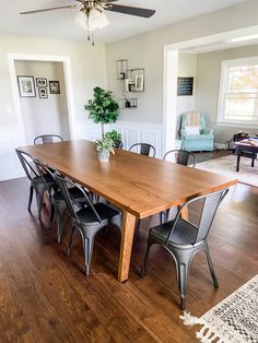 a dining room table with six chairs and a ceiling fan in the middle of it