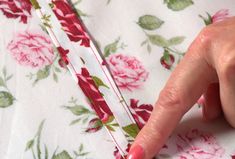 a woman's finger is pointing to the side of a flowered dress with pink flowers on it