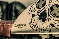 a close up of a motorcycle with a skull painted on it's front fender