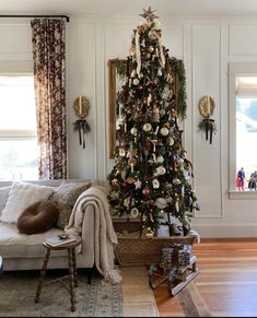 a living room with a christmas tree in the corner and other decorations on the wall