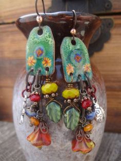 a pair of colorful earrings sitting on top of a vase