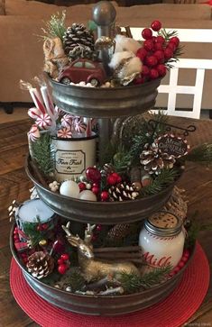 a three tiered christmas tree with candles and ornaments on the top, sitting on a table