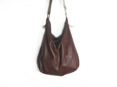 Handmade leather hobo bag make with soft brown leather and brown strong leather. This bag is unlined. Inside there is a big cotton pocket close with zip. Inside there is a leather string with a carabiner for your keys or phone case or for a purse. The bag is closed with a zip. The shoulder belt is made with stronger brown leather. This confortable hobo bag is very practical for any occasion. This bag is very large and soft and may contain many things. Features : - Color brown, - Unlined, - Metal Versatile Brown Hobo Bag With Zipper Pocket, Chic Brown Hobo Bag With Zipper Pocket, Modern Brown Hobo Bag With Adjustable Strap, Modern Brown Hobo Bag With Removable Pouch, Versatile Brown Hobo Bag With Leather Lining, Brown Hobo Shoulder Bag With Zipper Closure, Versatile Brown Shoulder Bag With Leather Lining, Brown Hobo Shoulder Bag With Zipper Pocket, Versatile Brown Leather Hobo Bag