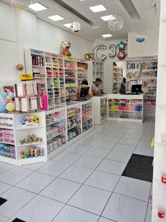 the inside of a store with people working at their desks and shelves full of items