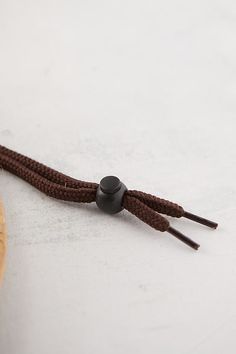 a pair of black and brown ear buds sitting on top of a piece of wood