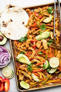 a tray filled with chicken and vegetables next to tortillas