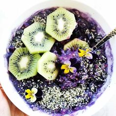 a bowl filled with blueberries, kiwis and chia seeds on top of it