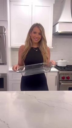 a woman in a black dress is holding a tray