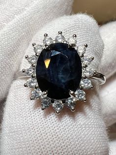 a ring with a large blue stone surrounded by small white diamonds