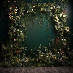 an artistic photo with flowers and greenery on a green wall in front of a wooden floor