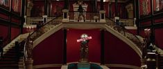 an ornate staircase in a building with red walls and white railings that reads welcome