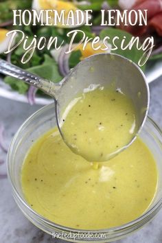 homemade lemon poppy dressing in a small glass bowl with a ladle full of dressing