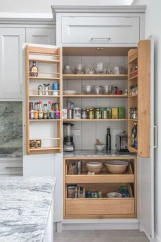 an open cabinet in a kitchen filled with food