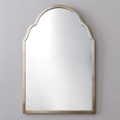 an arched mirror mounted on the wall