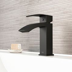 a black faucet sitting on top of a white counter