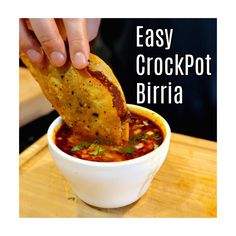 a hand dipping some food into a bowl with the words easy crockpot birra