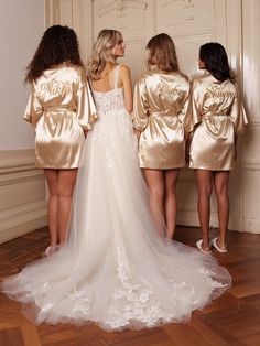 three bridesmaids in gold robes looking at each other