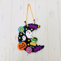 an ornament hanging on the wall with candy and halloween decorations in it's hands