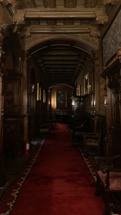 a long hallway with red carpet and wooden furniture