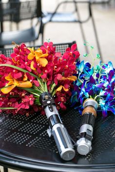 colorful flowers are sitting on top of a table with two dynamites in front of them