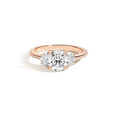 a rose gold engagement ring with two round diamonds on the top and bottom, set against a white background