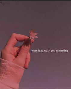 a person holding a small butterfly in their hand with the words everything teach you something