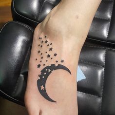 a person's foot with stars and a crescent moon tattoo on the left side of their foot