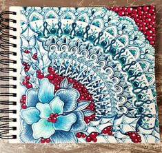 a spiral notebook with blue and red flowers on it