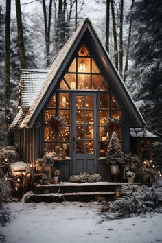 a small cabin in the woods with christmas lights on it's windows and door