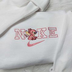 The Angel Stitch Nike Embroidered Sweatshirt is a must-have for any Stitch fan. Made with premium quality materials, this sweatshirt features an adorable Angel Stitch embroidery, adding a touch of cuteness to your wardrobe. With its comfortable fit and cozy fabric, it offers both style and comfort. Perfect for casual or loungewear, this sweatshirt is a great addition to any outfit. Get ready to showcase your love for Lilo & Stitch with this trendy and unique embroidered hoodie. Made with sof Custom Nike Hoodie, Lilo And Stitch Hoodie, Stitch Nike, Nike Embroidered Sweatshirt, Jumper Ideas, Angel Stitch, Crewneck Embroidery, Stitch Sweatshirt, Clothes Business