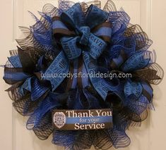 a blue and black mesh wreath with thank you for your service tag hanging on the front door