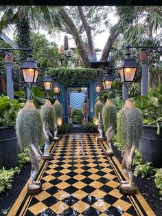 an outdoor garden with potted plants and lights on either side of the entrance way