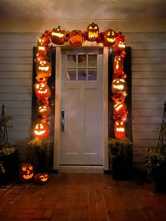 a front door decorated for halloween with pumpkins