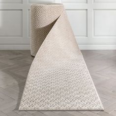 a white rug on the floor in front of a wall