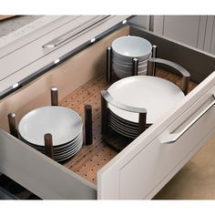 an open drawer with plates and bowls in it